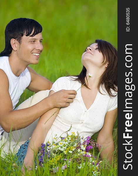 Man flirting with woman in field. Man flirting with woman in field