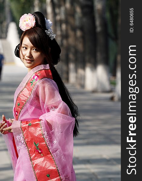 A girl in Chinese ancient dress. She wave pleasant posture. A girl in Chinese ancient dress. She wave pleasant posture..