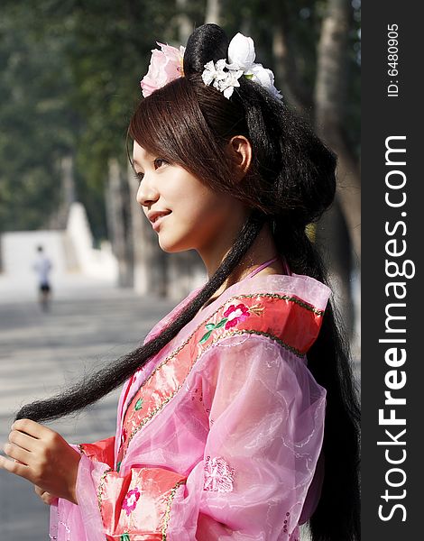 A girl in Chinese ancient dress. She wave pleasant posture. A girl in Chinese ancient dress. She wave pleasant posture