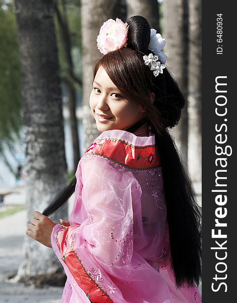 A girl in Chinese ancient dress. She wave pleasant posture. A girl in Chinese ancient dress. She wave pleasant posture..