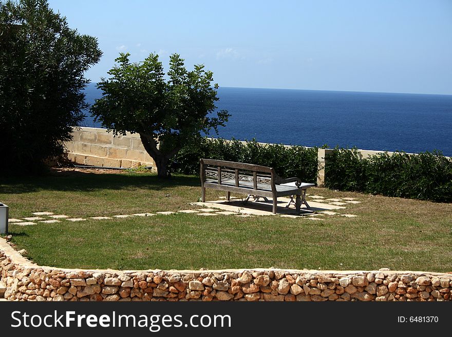 A park bench in a garden with a view. A park bench in a garden with a view