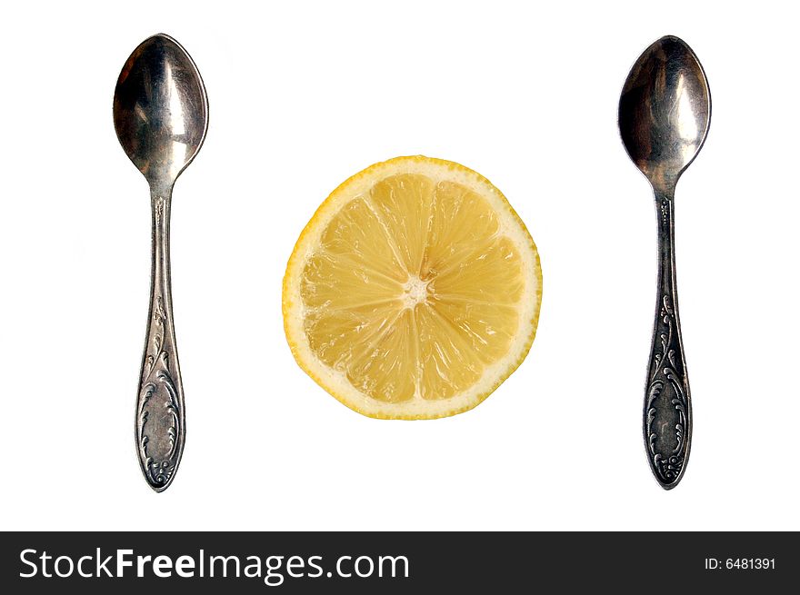 Two spoons and lemon slice on white background