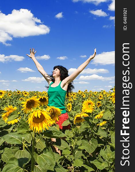 Fun woman in the field of sunflowers