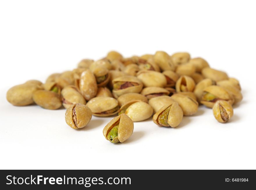 Heap of salty pistachios isolated. Soft focus
