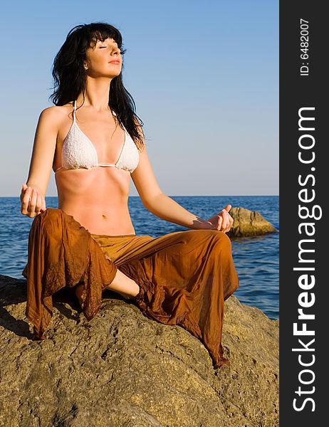 Young woman meditation in the beach