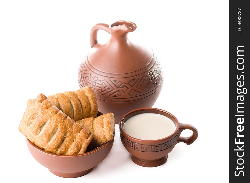 Appetizing pie, jug and cup of milk on a white background