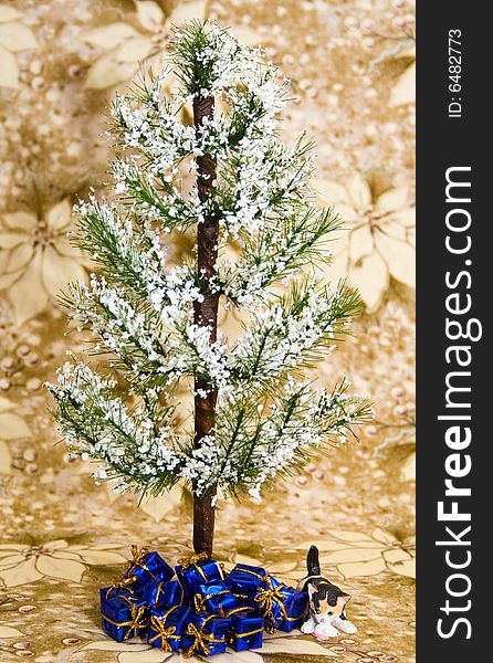 Winter holiday tree with blue presents and a little cat ornament underneath. Background is white / gold poinsettia.