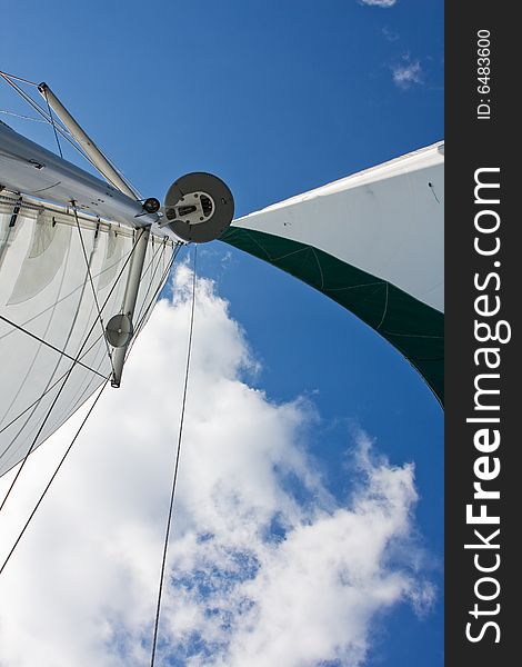 Sails, GPS and radar of a catamaran boat with a deep blue sky and white cloud