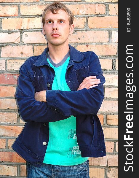 Young stylish man with blonde hair stand near brick wall. Young stylish man with blonde hair stand near brick wall.