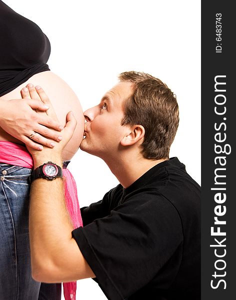 Father kissing the belly of his pregnant wife. Father kissing the belly of his pregnant wife