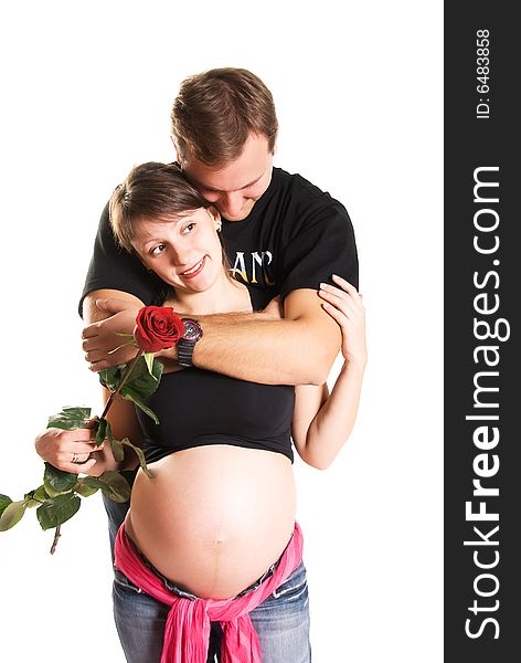 Pregnant woman holding a rose and her husband isolated against white background. Pregnant woman holding a rose and her husband isolated against white background