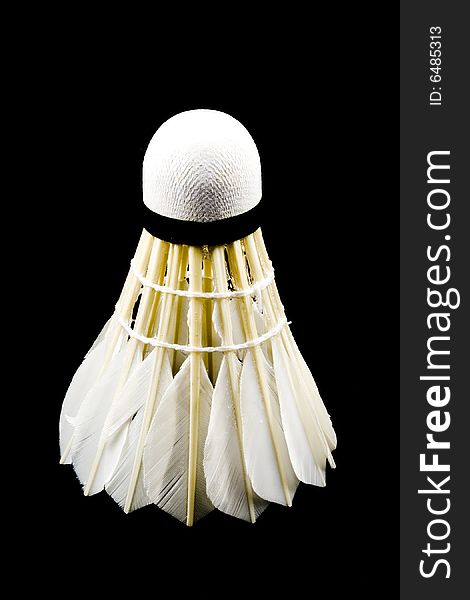 A white shuttlecock with feathers on the black background