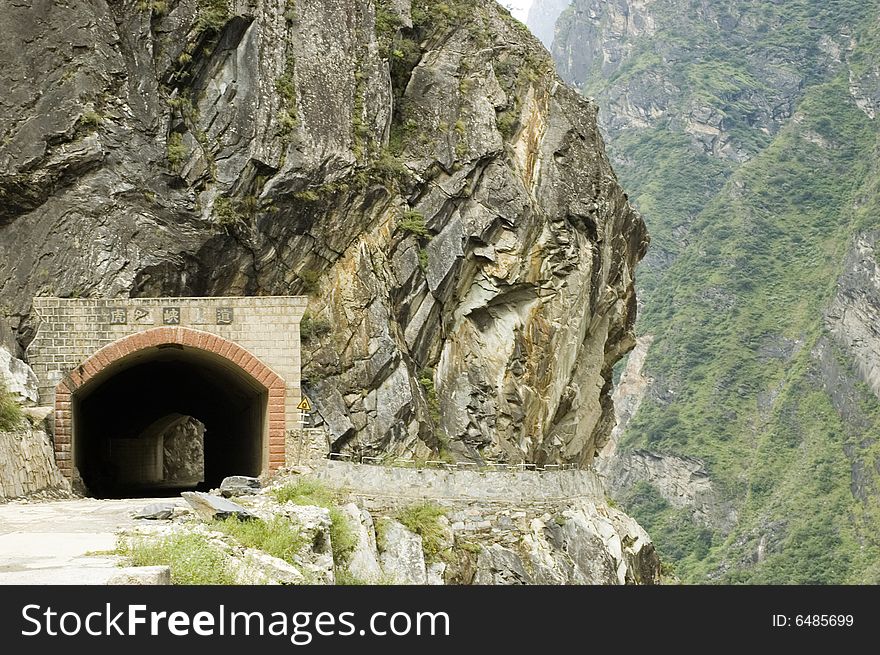 Sino-Tibetan mountains in Yunnan province, near Lijiang city, China. Old tunnel in mountains.