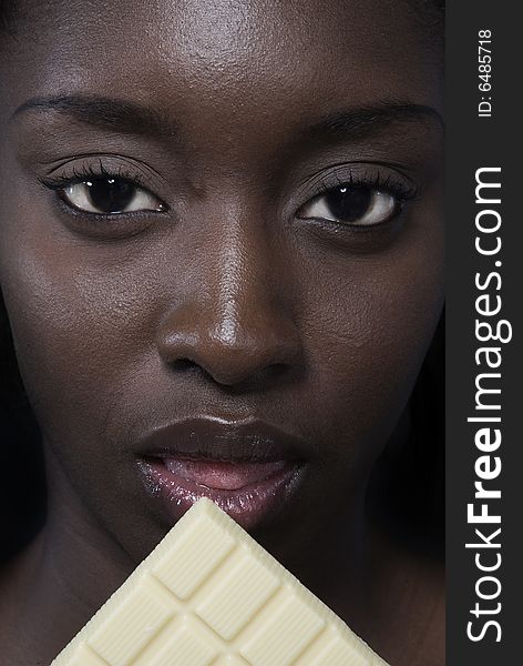 Portrait of a black woman eating a bar of choccolate. Portrait of a black woman eating a bar of choccolate