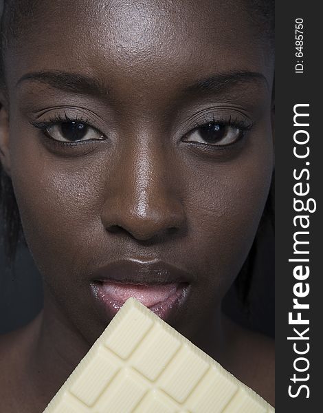 Portrait of a black woman eating a bar of choccolate. Portrait of a black woman eating a bar of choccolate