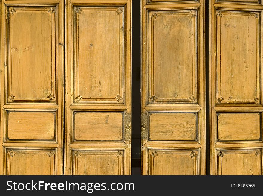 Ancient, wooden door painted in yellow color, house in Shangrila, Yunnan province, China.