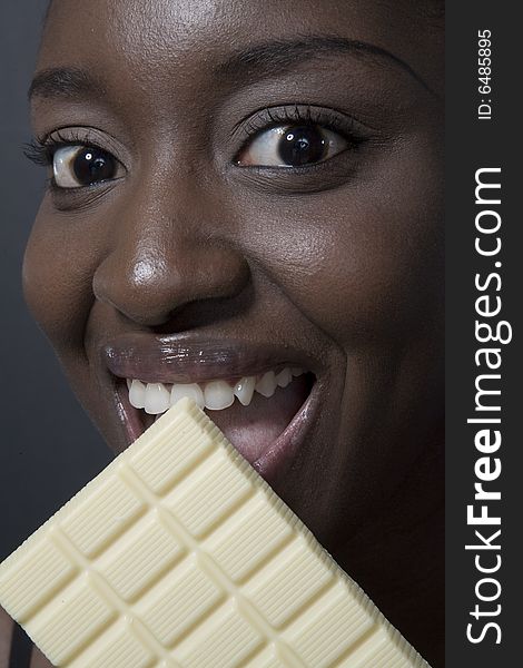 Portrait of a black woman eating a bar of choccolate. Portrait of a black woman eating a bar of choccolate