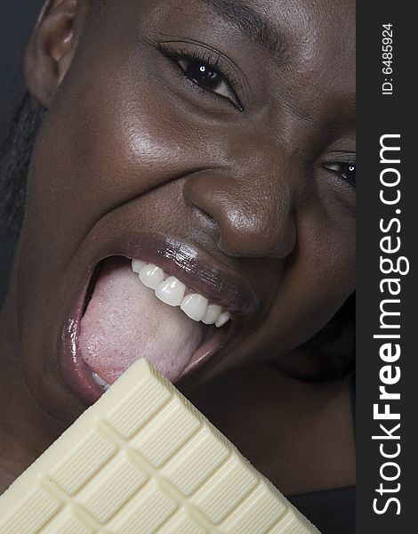 Portrait of a black woman eating a bar of choccolate. Portrait of a black woman eating a bar of choccolate