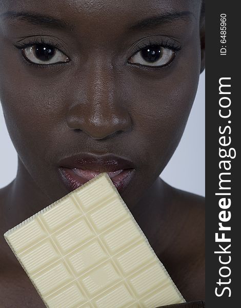 Portrait of a black woman eating a bar of choccolate. Portrait of a black woman eating a bar of choccolate