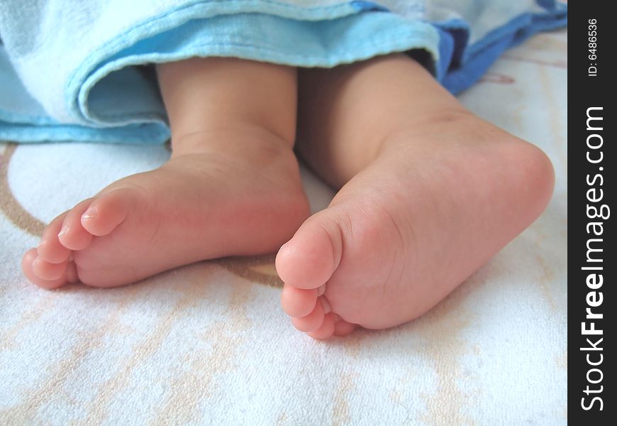 Little feet under blue sheet