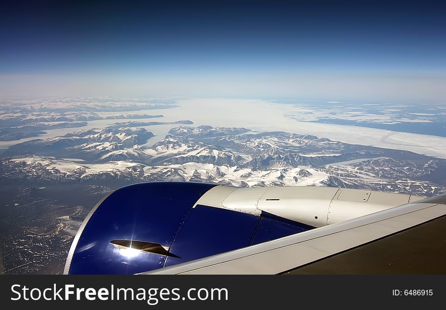 Jet engine of aircraft flying over ice field of Greenland. Jet engine of aircraft flying over ice field of Greenland.