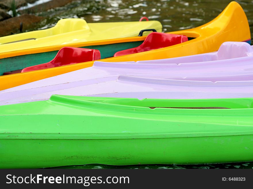 Photo of coloured canoes ashore of the lake