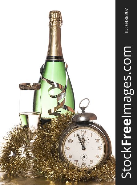Champagne with glass, old alarm clock and golden decoration