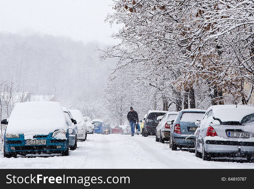 Man walking on a icy road during snowstorm