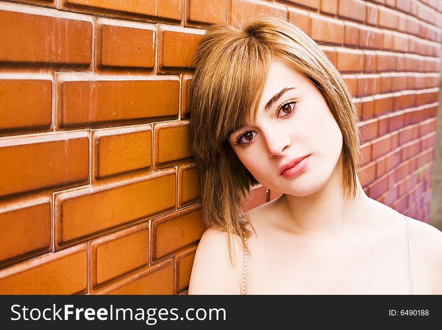 Beautiful blond woman on brick wall. Beautiful blond woman on brick wall