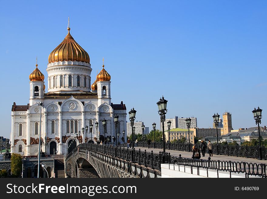 The bridge through the river, on each side the bridge lanterns, on a distance shot, church. The bridge through the river, on each side the bridge lanterns, on a distance shot, church