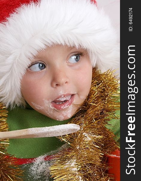 Toddler wearing a christmas hat, baking christmas cookies