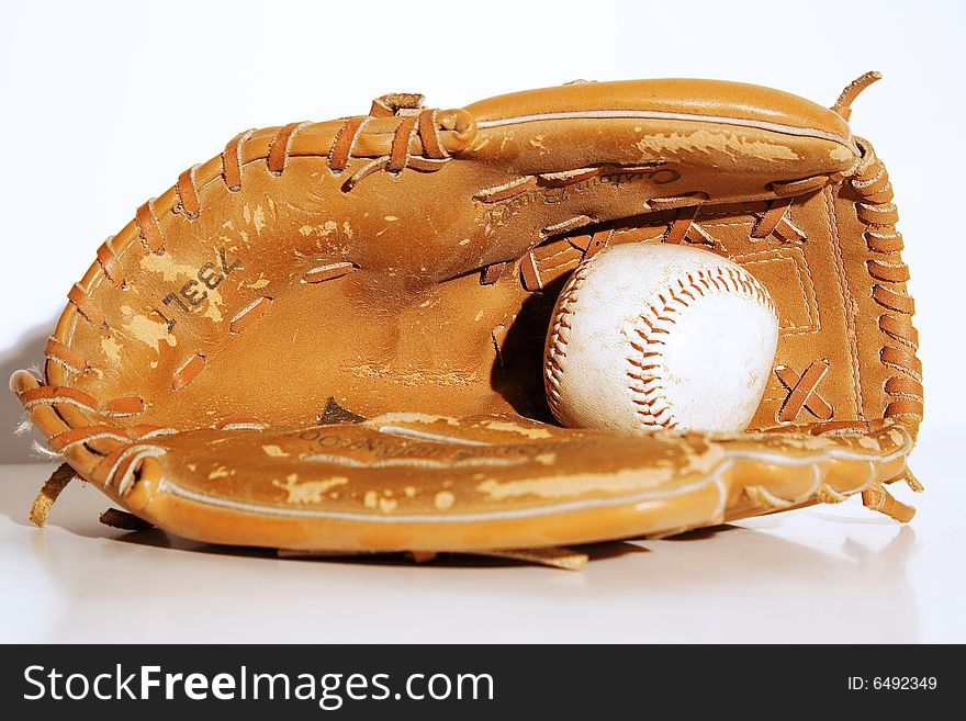 Close up of a vintage baseball mitt and baseball.