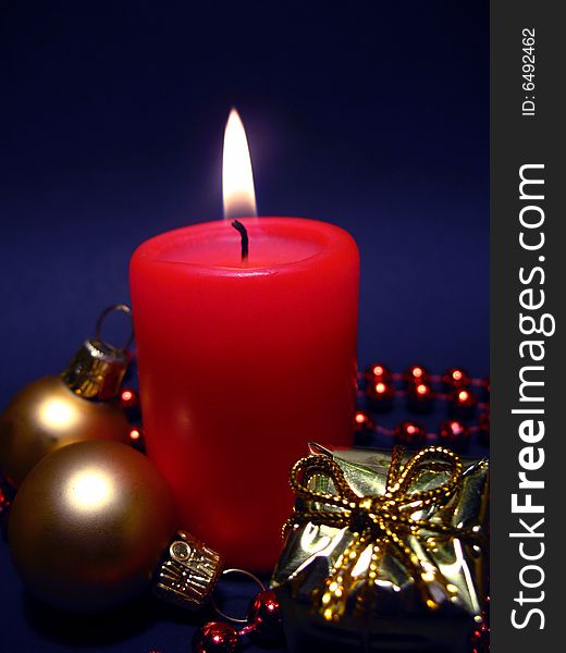 Red candle on black background, Christmas still life with candle, balls and present