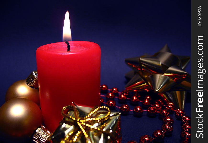 Red candle on black background, Christmas still life with candle, balls and present