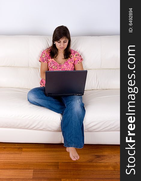 Beautiful Young Woman With Laptop On Sofa