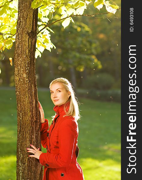 Beautiful blond woman with autumn leaves outdoors
