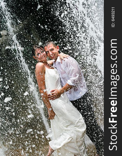 Bride and groom dancing under a water fountain on their wedding day. Bride and groom dancing under a water fountain on their wedding day.