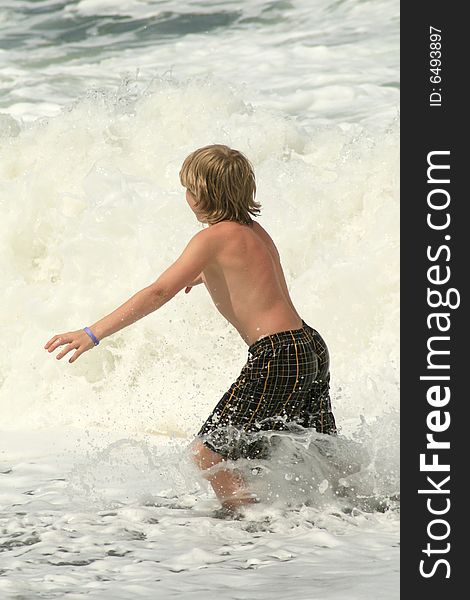 Young boy trying to run from the powerful waves. Young boy trying to run from the powerful waves