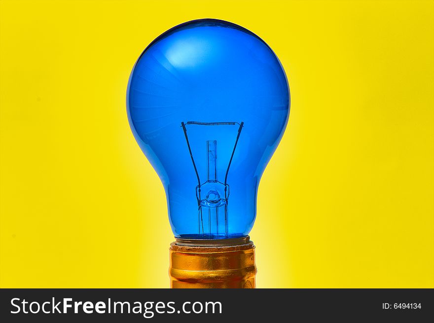 Blue light bulb isolated over yellow background