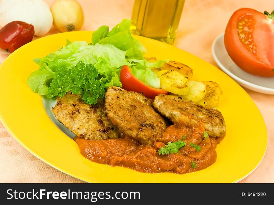 Baked hamburger with tomato sauce,fried potatoes ,salad.