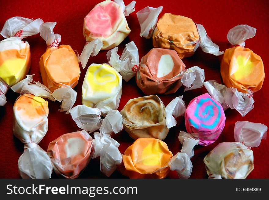 Colorful wrapped taffy on red background. Colorful wrapped taffy on red background