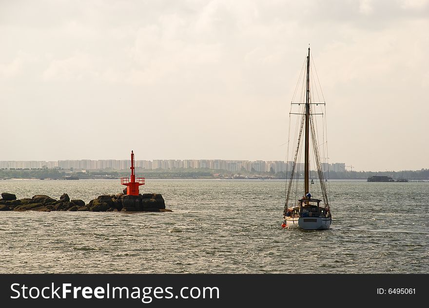 Yacht moored beside a navigation beacon build on a shoal of rocks. Yacht moored beside a navigation beacon build on a shoal of rocks