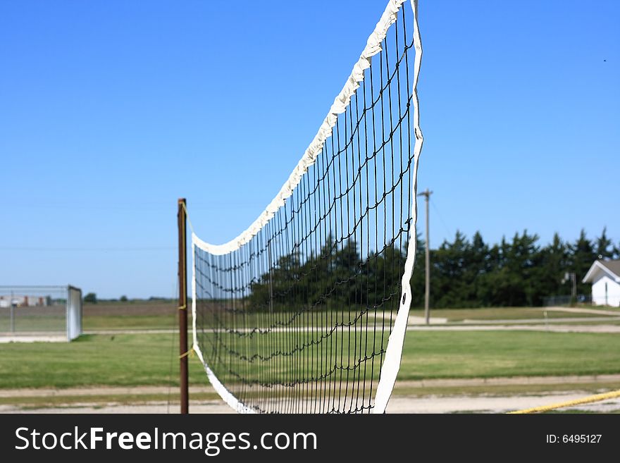 An outdoor volleyball net in a city park.