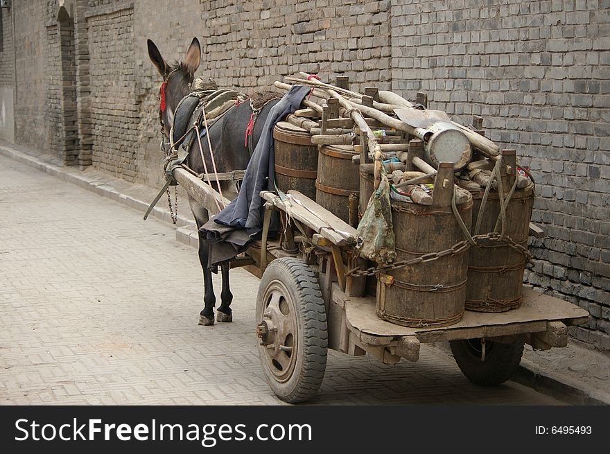 A donkey car with some barrels.