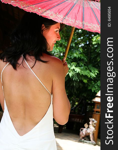 Portrait of a beautiful brunette bride with a red parasol. Portrait of a beautiful brunette bride with a red parasol.