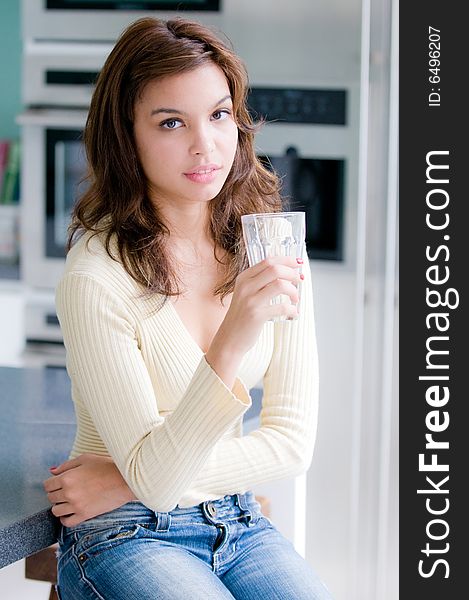 An attractive young woman at home in her kitchen. An attractive young woman at home in her kitchen