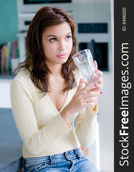 An attractive young woman at home in her kitchen. An attractive young woman at home in her kitchen