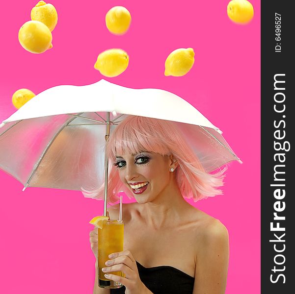 Beautiful smiling girl holding a glass of lemonade and an umbrella over her head as lemons rain down on her from the sky.  Isolated on a pink background. Beautiful smiling girl holding a glass of lemonade and an umbrella over her head as lemons rain down on her from the sky.  Isolated on a pink background.