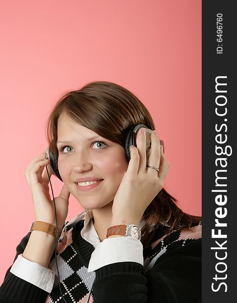 The girl in headphones on a pink background