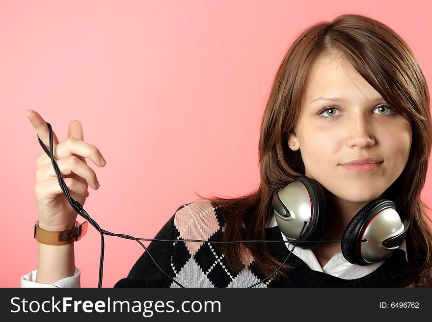 The girl in headphones on a pink background